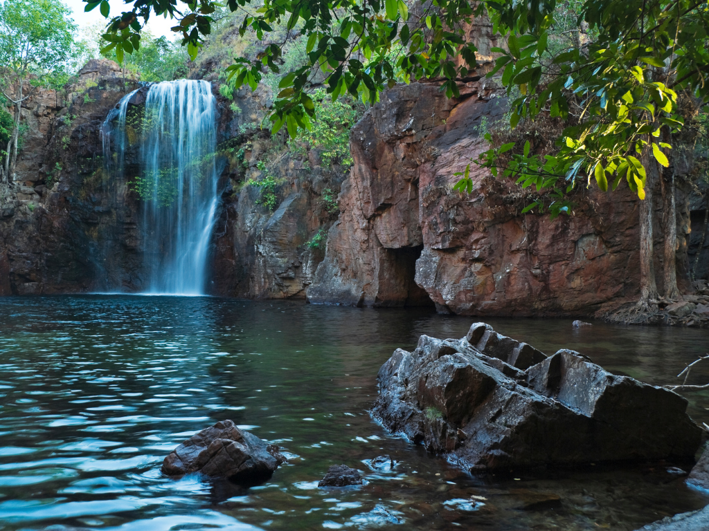Florence Falls in Litchfield National Park offers a picturesque scene of cascading water surrounded by lush greenery, inviting visitors to experience the tranquility of this natural oasis.
