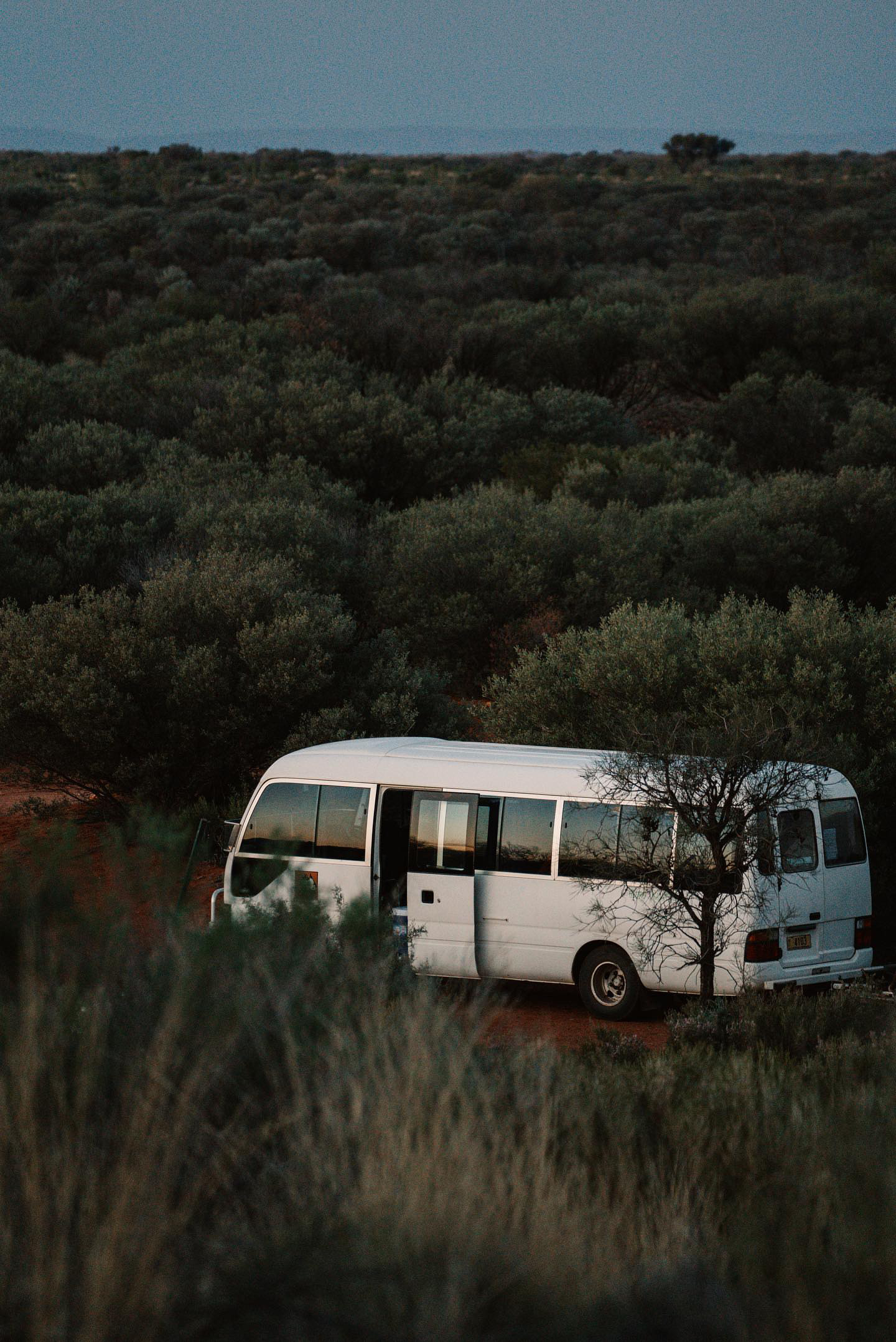 Our Mulgas Adventures bus finds a serene spot in the heart of Australia's Red Centre. Photo credit: Nastasia Klopp. Instagram: @nastasiaklopp