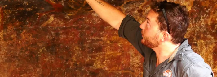 Mulgas Adventures tour guide Alex explaining ancient rock art in the Australian outback