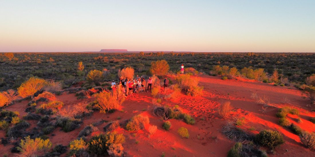 Group of Mulgas Adventures tour group exploring the red sand dunes at sunset in the Australian outback